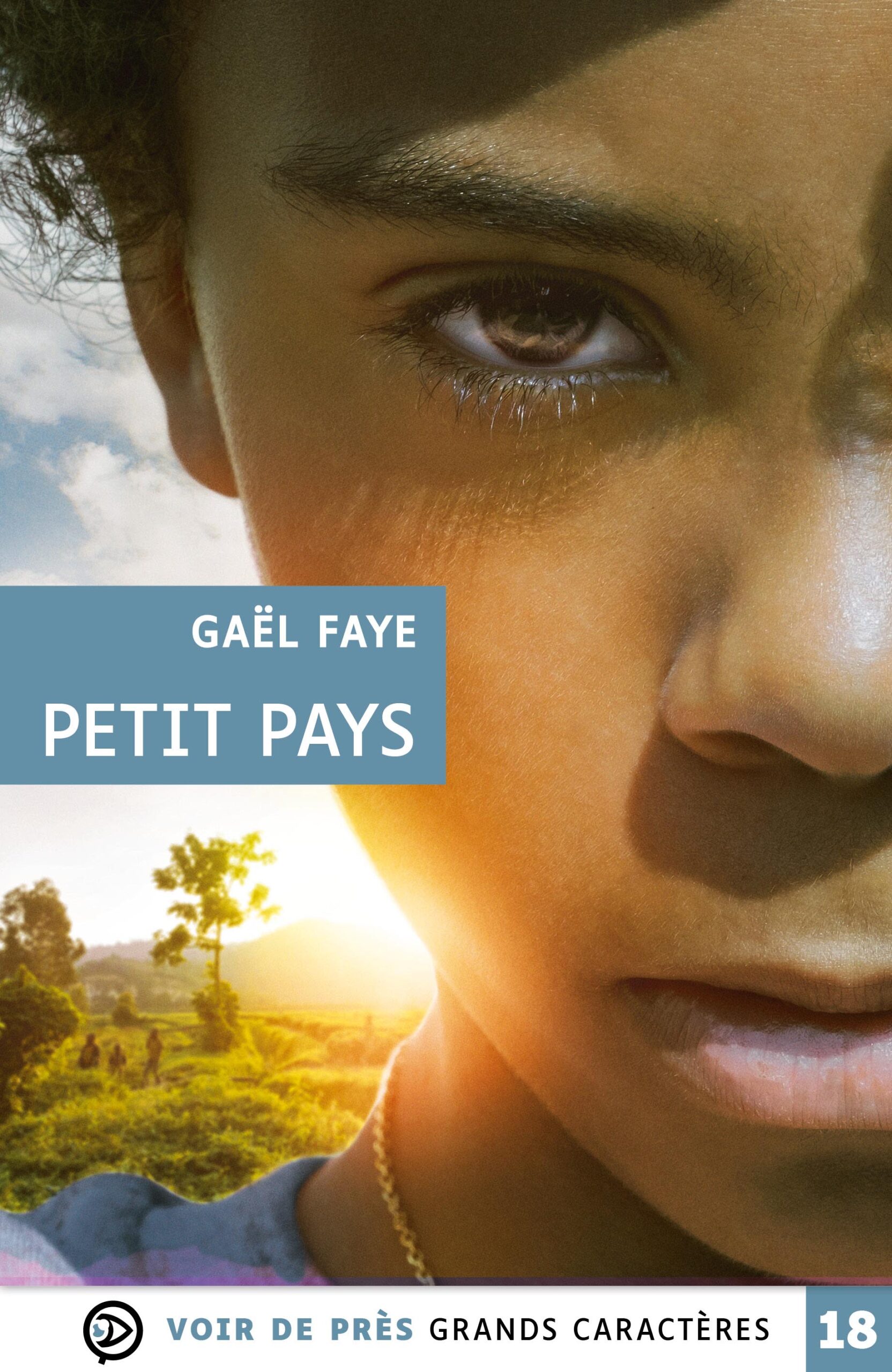 Couverture du livre en grands caractères intitulé Petit Pays de Gaël Faye, publié par Les éditions Voir de près. La couverture présente un gros plan du visage d’un enfant, dont un œil est particulièrement mis en avant, avec une lumière chaude sur la peau. En arrière-plan, un paysage rural apparaît avec des collines, un arbre et des silhouettes marchant dans un champ au coucher du soleil. L’ensemble mêle portrait et paysage dans des tons dorés et naturels. Le nom de l’auteur et le titre apparaissent dans un encadré bleu. En bas de la couverture figure la mention « Grands caractères » avec un corps 18.